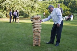 Man playing a life size giant jenga rental at an event.