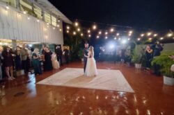 Picture of a wedding in south florida with outdoor market lighting. A bride and groom dances under the market lights we set up for their wedding.