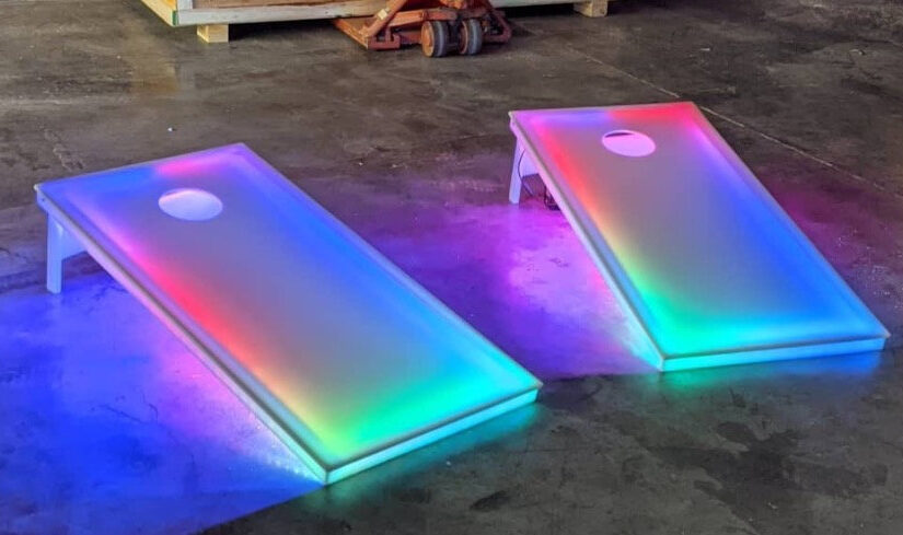 GLOW LED Cornholes being prepped for an event rental inside of a warehouse.